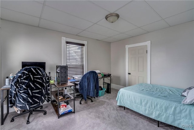 bedroom with baseboards, a drop ceiling, and carpet flooring