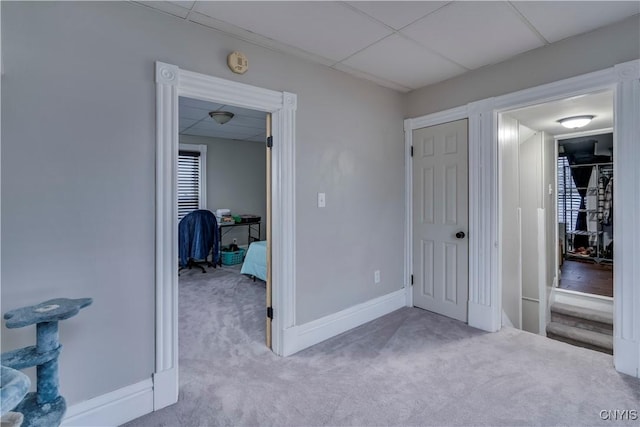 carpeted bedroom with a drop ceiling and baseboards