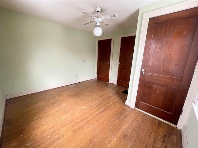 unfurnished room with ceiling fan, baseboards, and wood finished floors