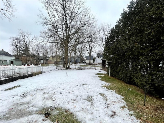 snowy yard featuring fence