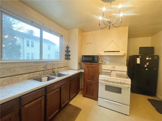 kitchen featuring light countertops, hanging light fixtures, a sink, a chandelier, and black appliances