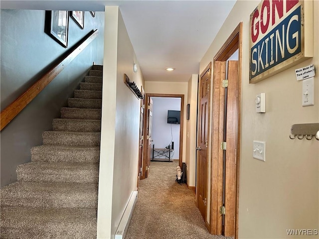 hallway with carpet floors, a baseboard radiator, stairway, and baseboards