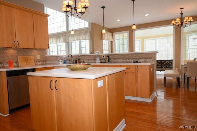 kitchen featuring a chandelier, light countertops, stainless steel dishwasher, and a center island