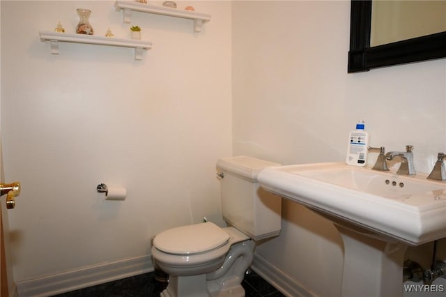 bathroom featuring baseboards and toilet