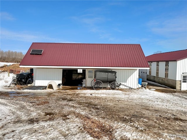 snow covered structure featuring an outbuilding