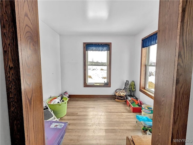 rec room featuring a healthy amount of sunlight, baseboards, and wood finished floors