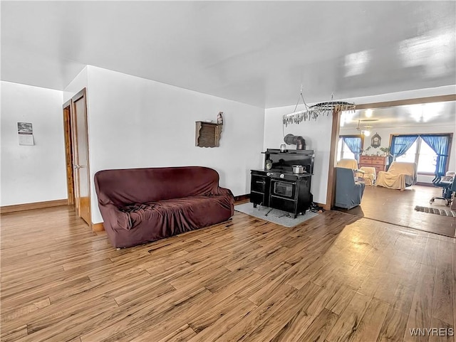 living room with wood finished floors and a wood stove