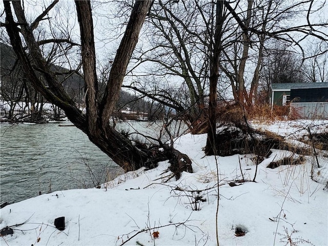 yard layered in snow featuring a water view