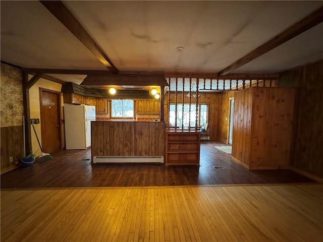 kitchen featuring dark wood-style floors, baseboard heating, beamed ceiling, and freestanding refrigerator