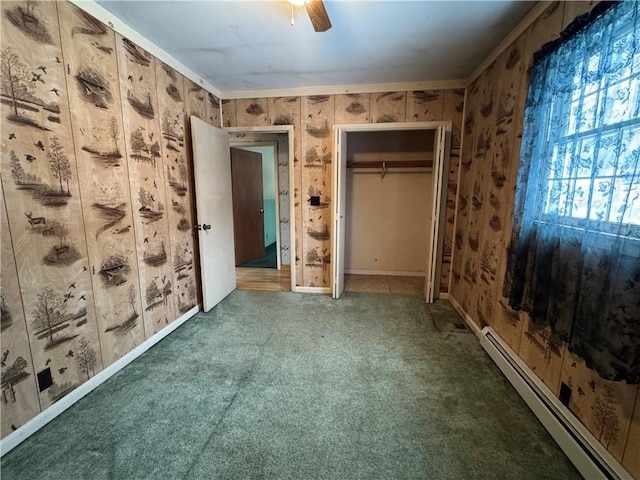 unfurnished bedroom with carpet floors, a ceiling fan, baseboard heating, and a closet