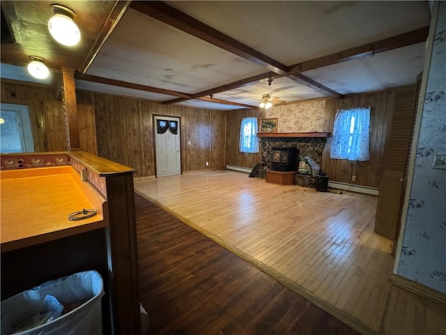 recreation room featuring ceiling fan, a baseboard heating unit, baseboard heating, beamed ceiling, and wood-type flooring