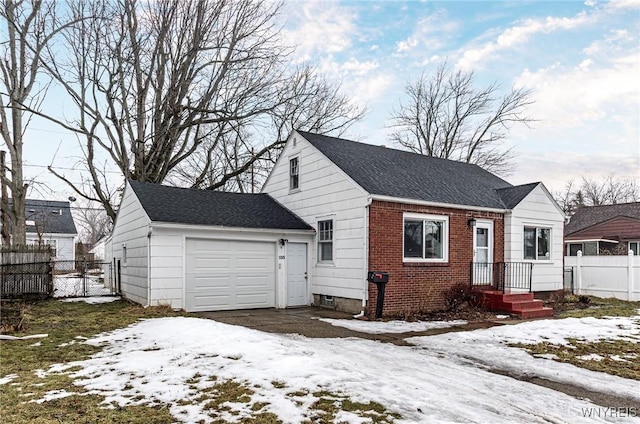 view of front of house with an attached garage, a shingled roof, fence, and brick siding