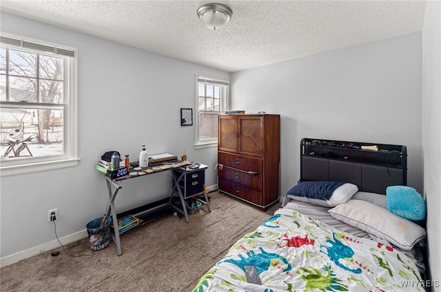 bedroom with carpet, a textured ceiling, and baseboards