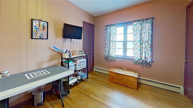 misc room featuring ornamental molding, a baseboard radiator, and wood finished floors