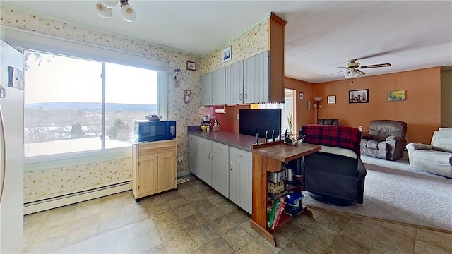 kitchen featuring black microwave, a ceiling fan, open floor plan, baseboard heating, and wallpapered walls