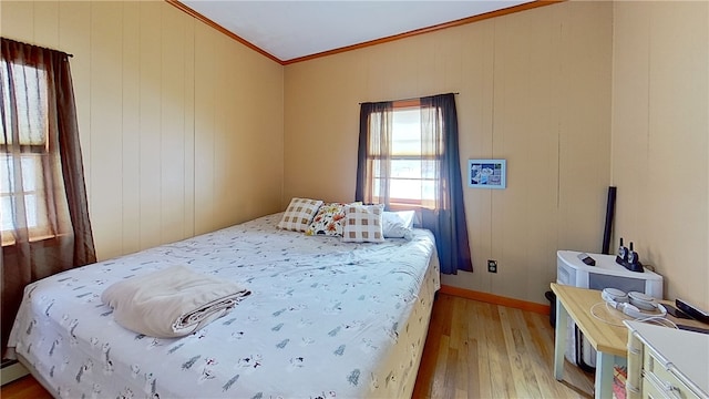 bedroom with crown molding and light wood finished floors