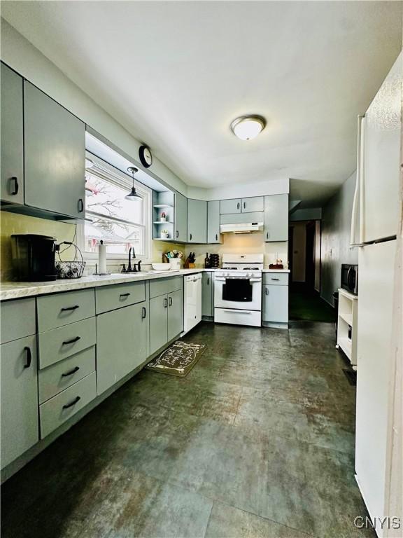 kitchen featuring white appliances, light countertops, under cabinet range hood, open shelves, and a sink