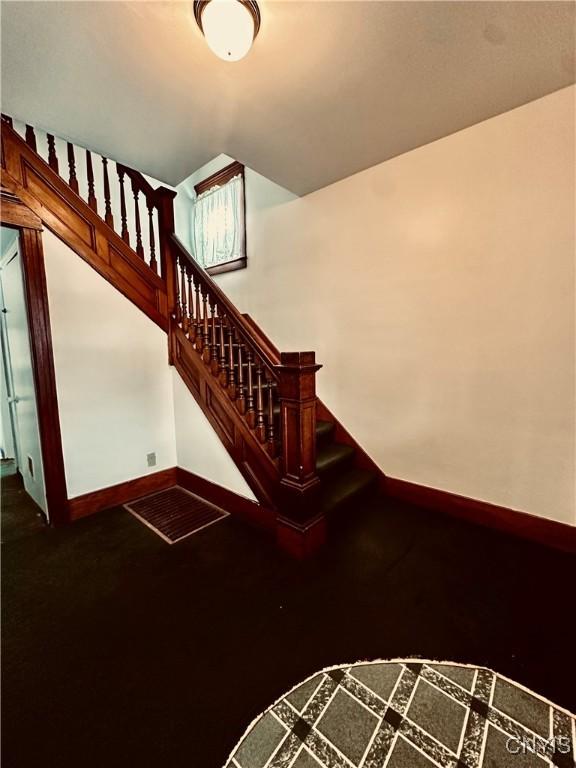 stairway featuring baseboards and wood finished floors