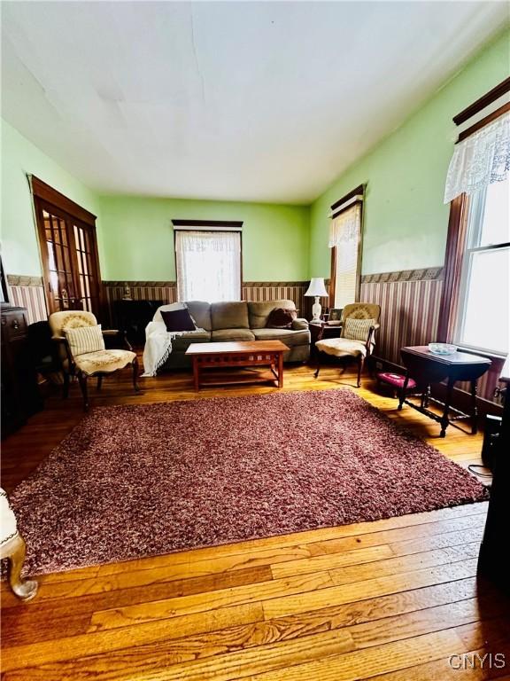 living room with hardwood / wood-style flooring and wainscoting