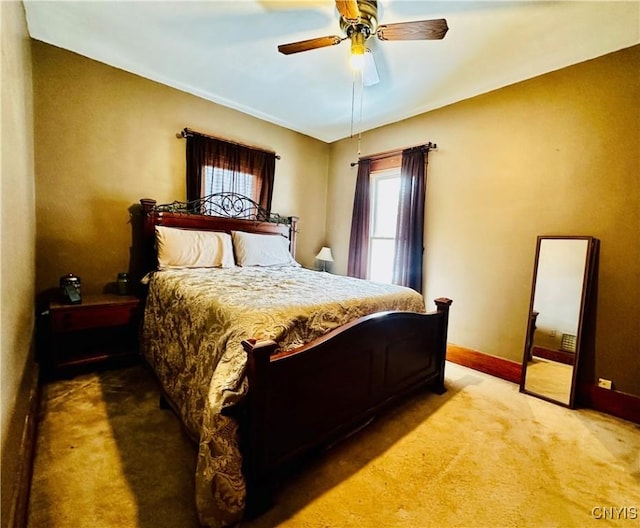 bedroom featuring light colored carpet, ceiling fan, and baseboards