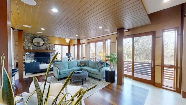 living area featuring recessed lighting, wooden ceiling, a fireplace, and wood finished floors