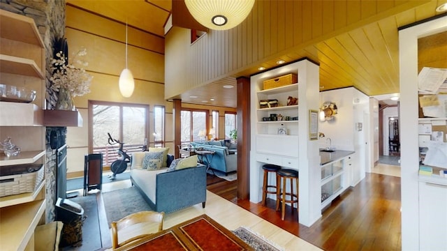 living room with wood walls, a high ceiling, and wood finished floors