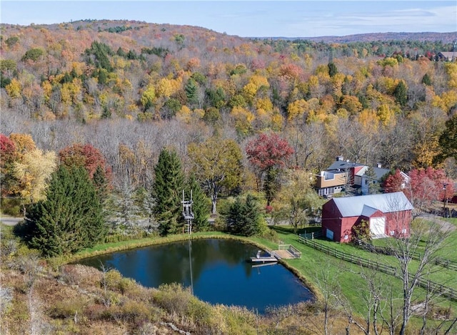 drone / aerial view with a forest view and a water view