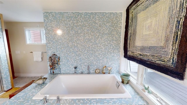 bathroom featuring tile walls and a bath