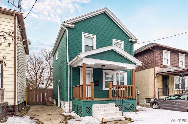 view of front of house featuring covered porch and fence