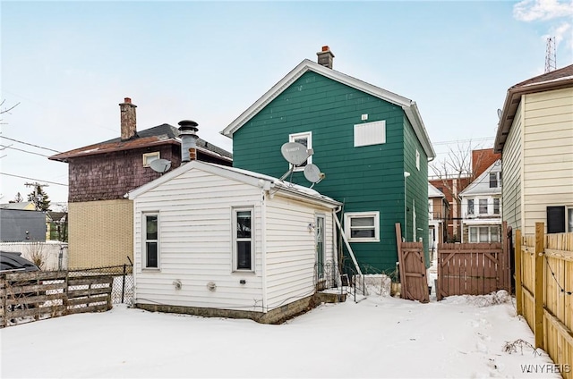 snow covered property with a gate and fence