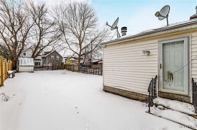 yard covered in snow with entry steps and fence