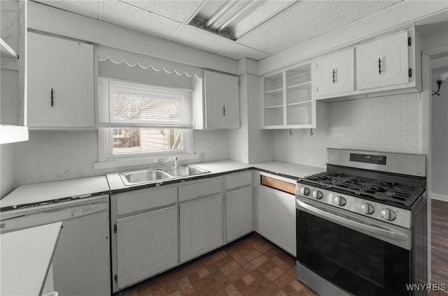 kitchen with white dishwasher, a sink, white cabinetry, open shelves, and gas range