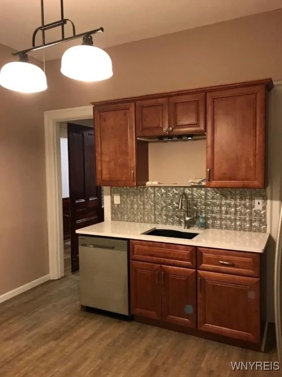 kitchen featuring a sink, tasteful backsplash, light countertops, and stainless steel dishwasher