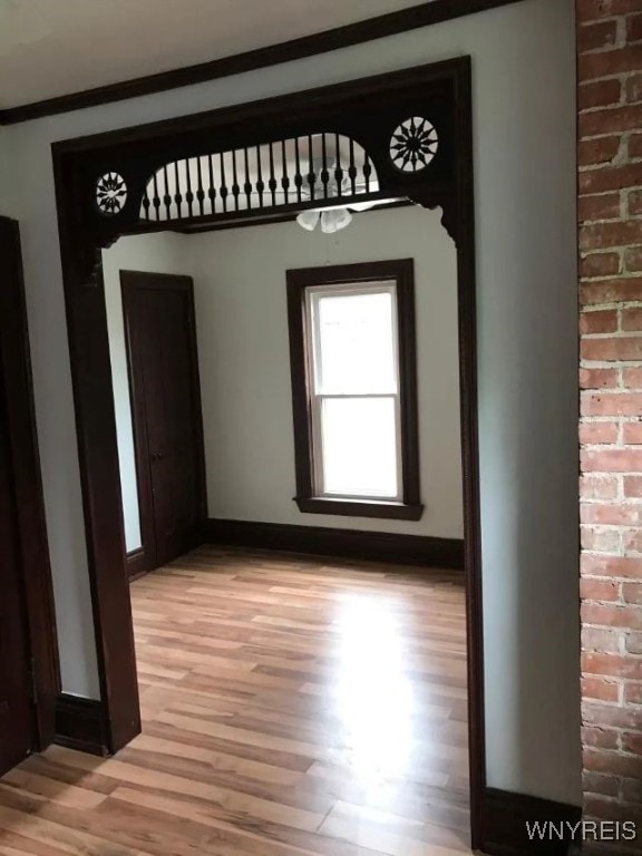 interior space featuring baseboards and light wood finished floors