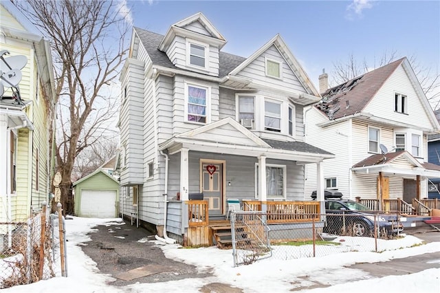 view of front of home with a porch, an outdoor structure, a shingled roof, and a garage