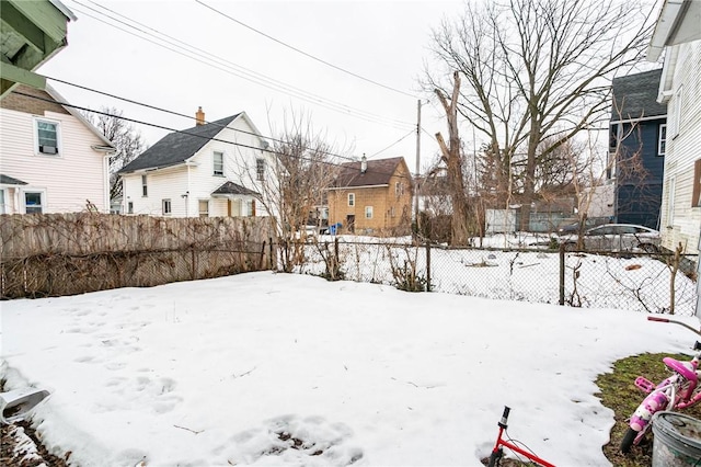 yard covered in snow with fence private yard and a residential view