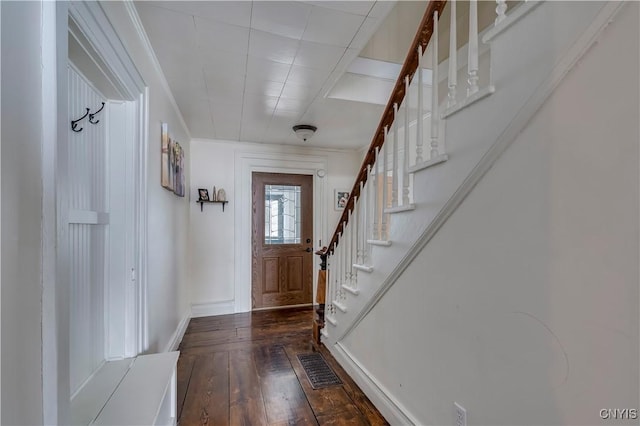 entrance foyer featuring baseboards, visible vents, hardwood / wood-style floors, and stairs