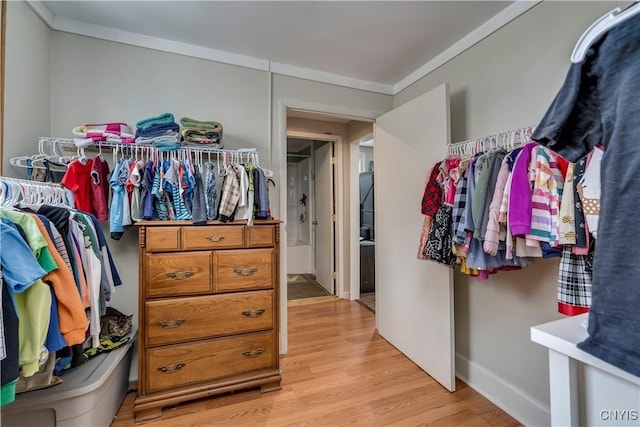 walk in closet with light wood-style floors