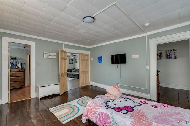 bedroom with baseboards, crown molding, and hardwood / wood-style floors