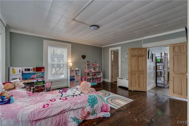 bedroom with ornamental molding, wood-type flooring, and baseboards