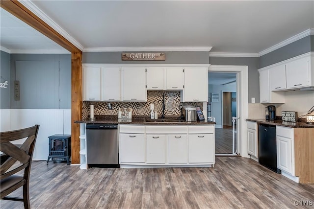 kitchen featuring ornamental molding, stainless steel dishwasher, wood finished floors, and white cabinets