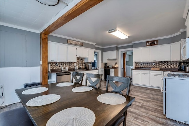 dining area featuring washer / dryer, crown molding, and light wood-style flooring