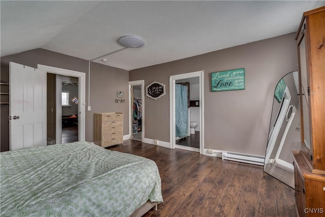 bedroom featuring a baseboard radiator, wood finished floors, baseboards, a closet, and a walk in closet