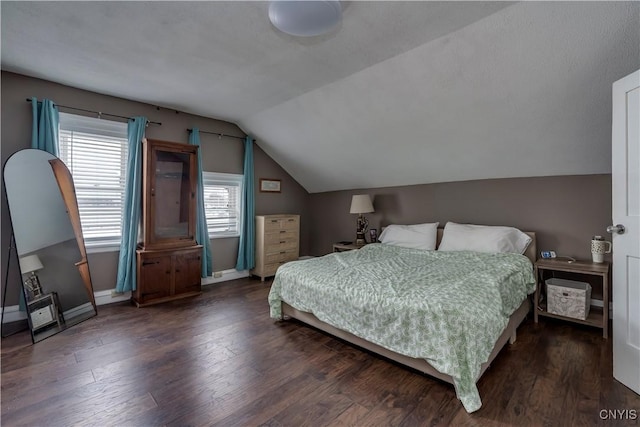 bedroom featuring baseboards, vaulted ceiling, and wood finished floors