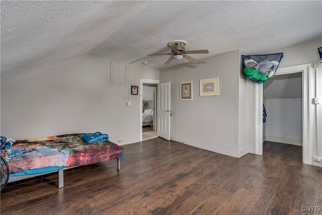 bedroom featuring lofted ceiling, ceiling fan, a textured ceiling, and wood finished floors