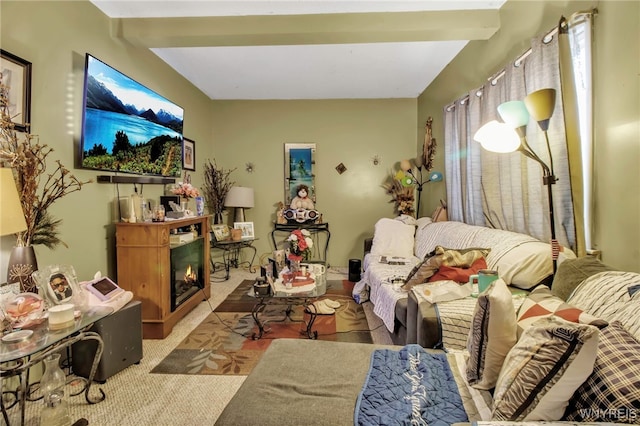 living area featuring a lit fireplace, carpet floors, and beam ceiling