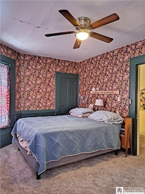 carpeted bedroom featuring ceiling fan and wallpapered walls