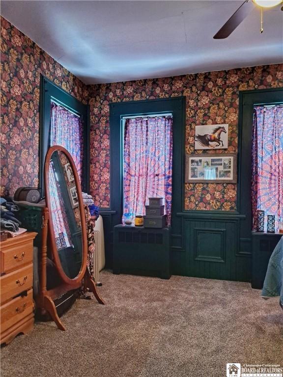 sitting room featuring carpet floors, wallpapered walls, and a ceiling fan