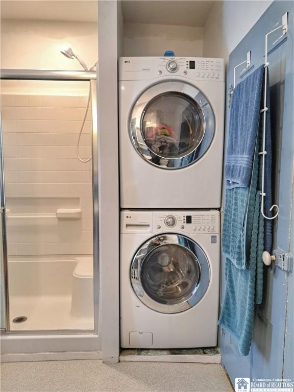 washroom with stacked washer and dryer and laundry area