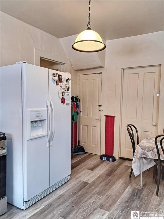 kitchen with light wood-type flooring, white refrigerator with ice dispenser, and stainless steel range with electric cooktop